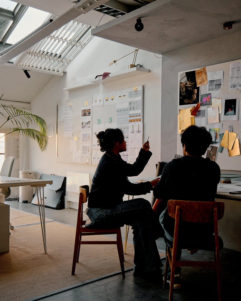 Two people sitting at a table in Atelier001 office